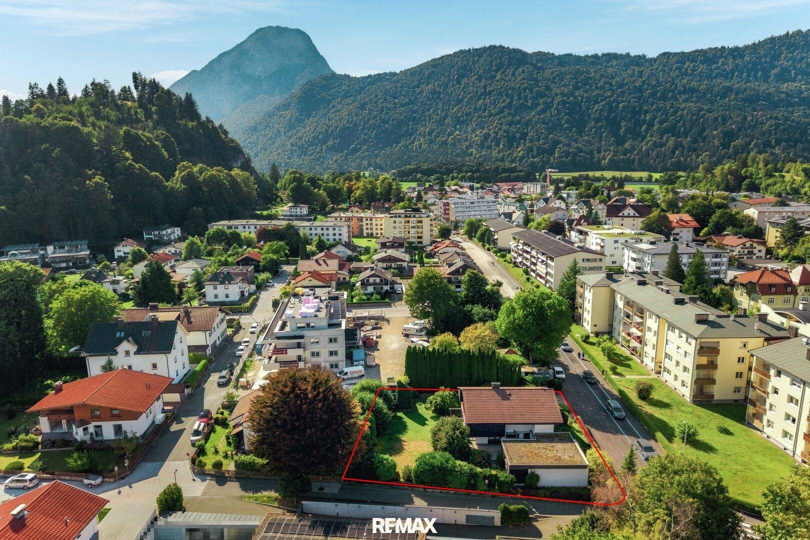 Luftaufnahme des Hauses und des Gartens, eingebettet in die städtische Landschaft mit Bergblick.