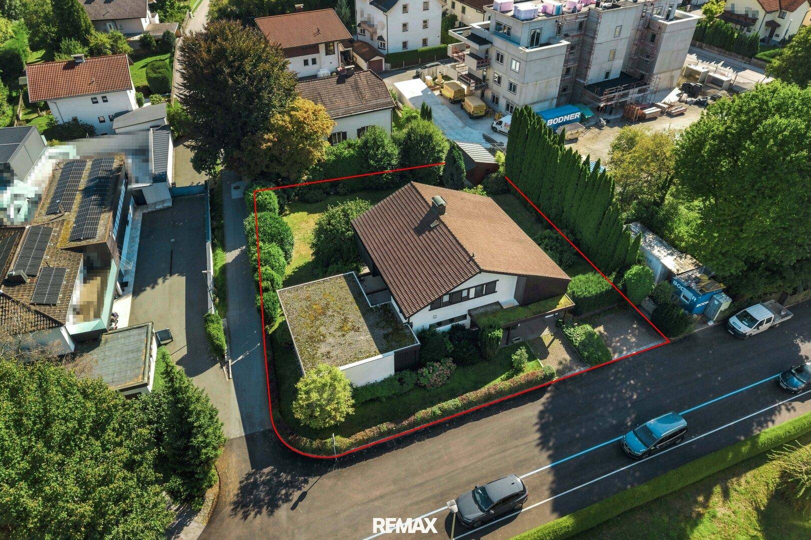 Luftaufnahme des Einfamilienhauses mit gepflegtem Garten und Blick auf eine nahegelegene Baustelle.