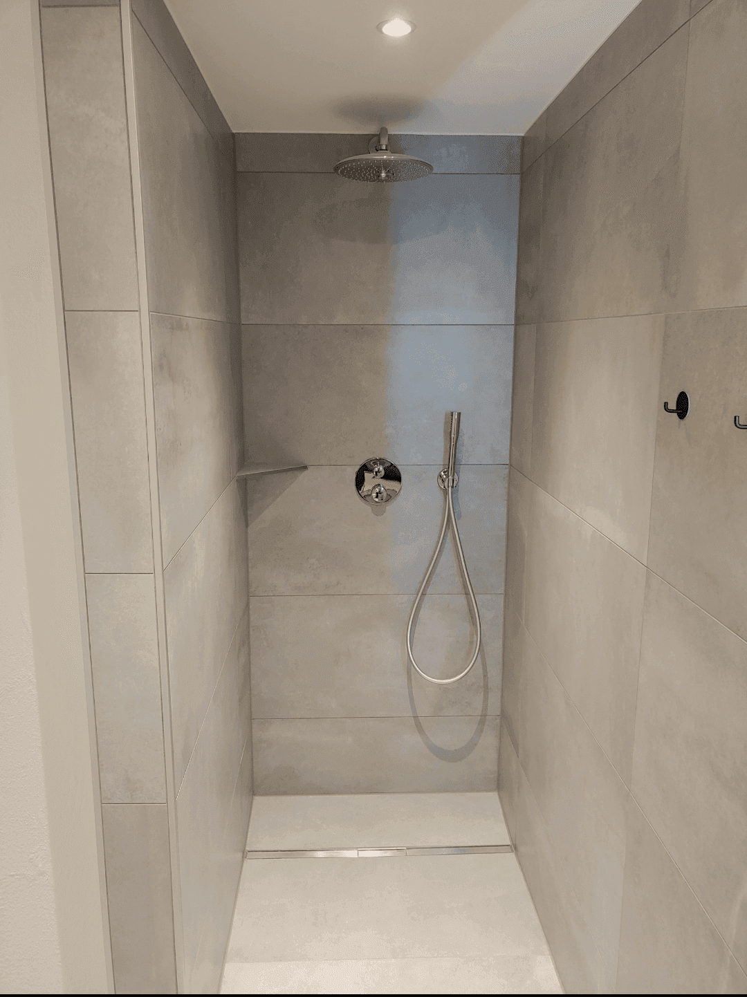 Geräumige begehbare Dusche mit Regenduschkopf und Handbrause in modernem Badezimmer.