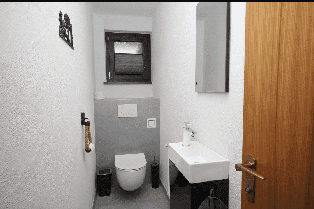 Kleines Gäste-WC mit modernem Wand-WC, Waschbecken und Fenster.