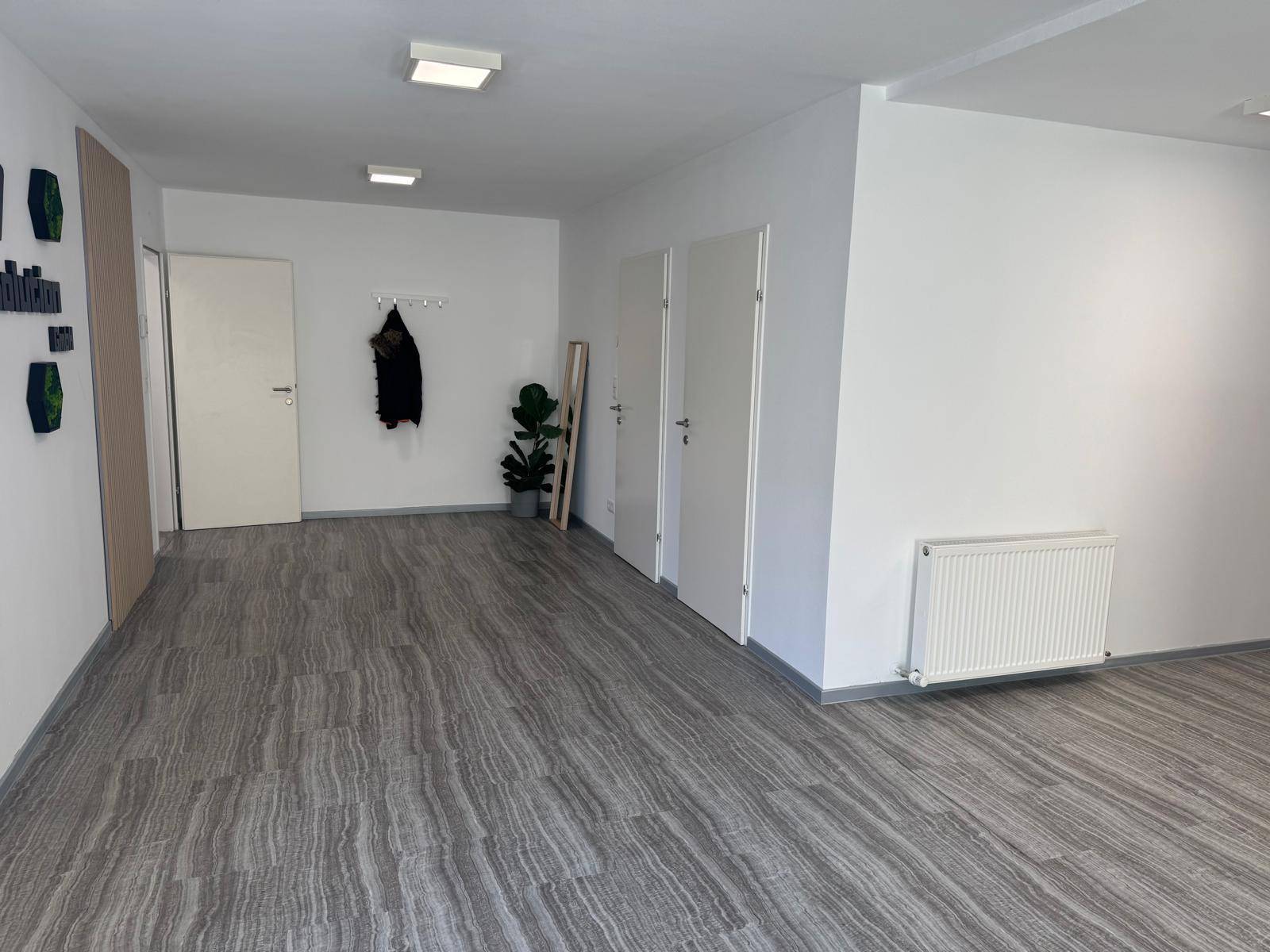 Geräumiger Eingangsbereich oder Flur mit Garderobe und mehreren Türen, heller Vinylboden.