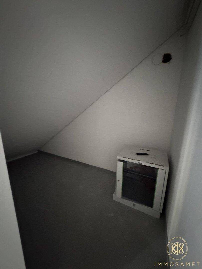 Kleiner Abstellraum im Dachgeschoss mit schrägen Wänden und einem Serverschrank.