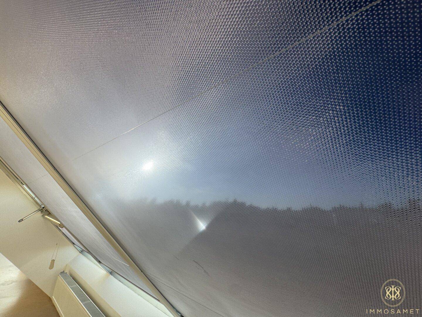 Detailaufnahme eines Fensterrollos im Dachgeschoss, das den Lichteinfall reguliert.