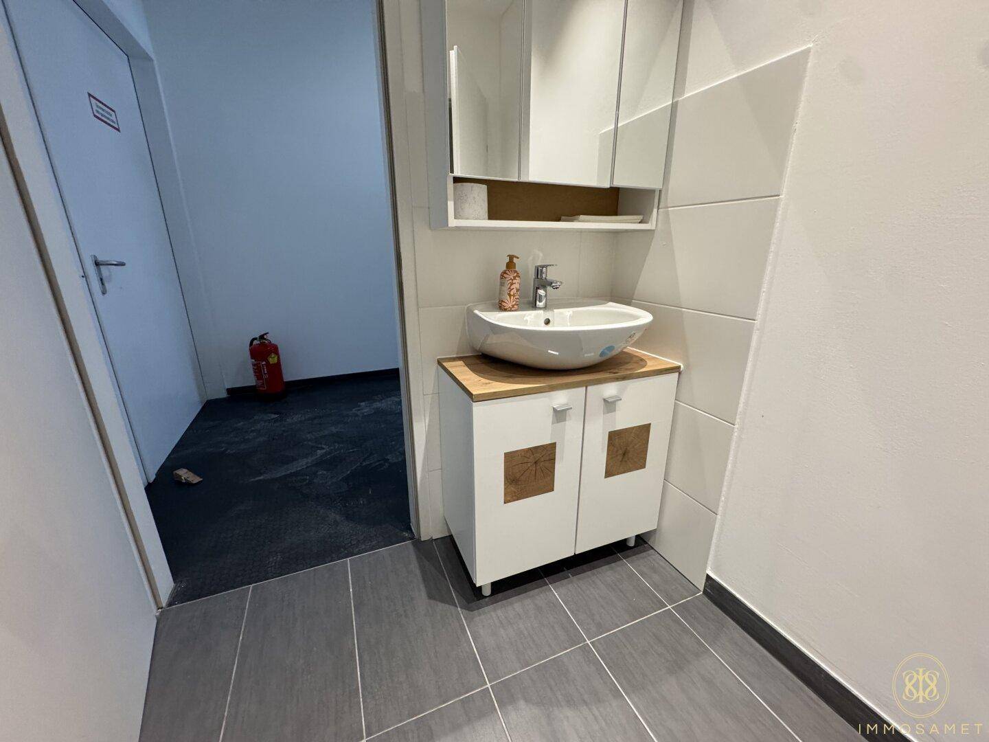 Moderner Waschbeckenbereich mit stilvollem Aufsatzwaschbecken, Unterschrank und Wandspiegel.