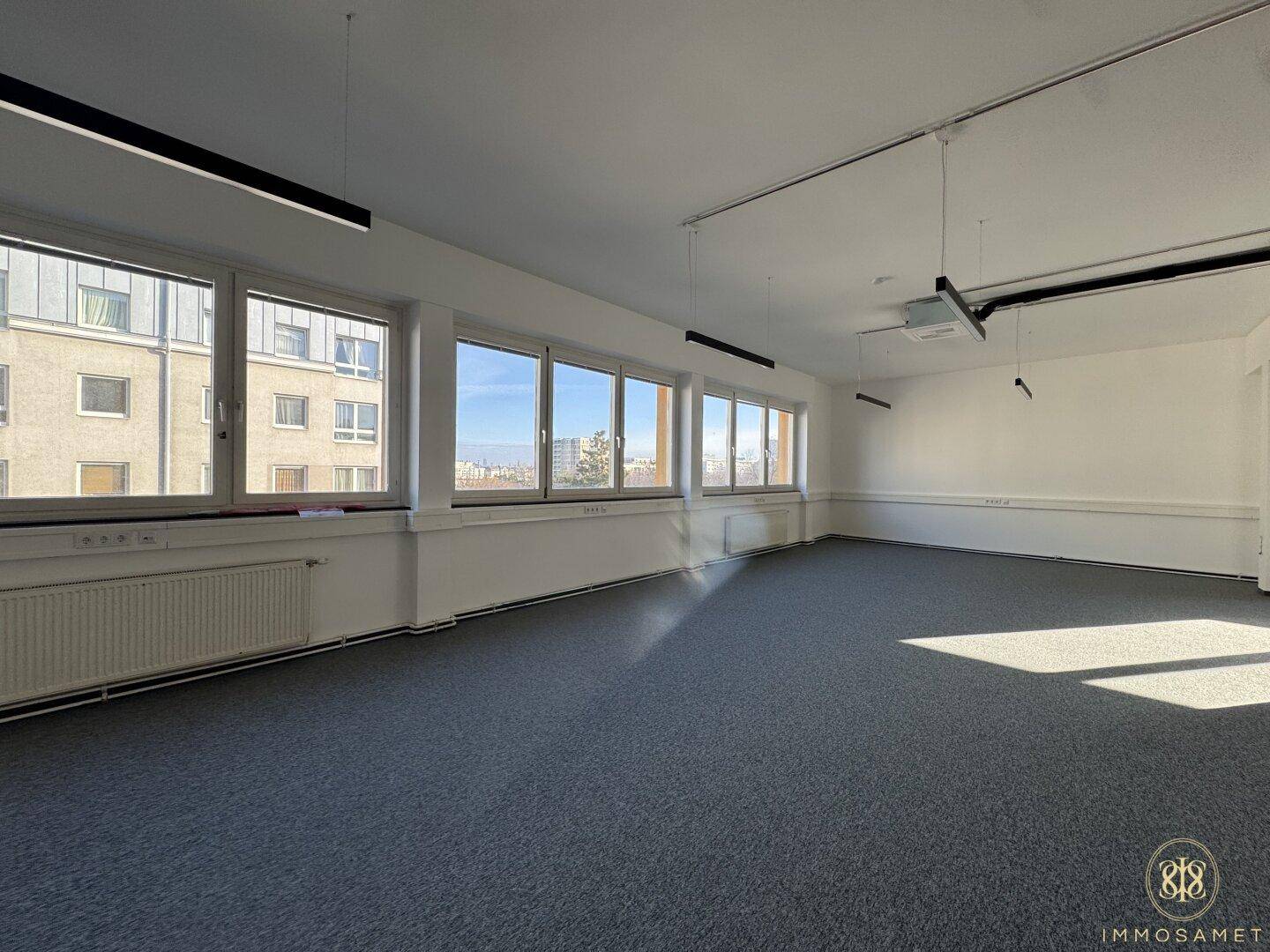 Weitläufiger, leerer Bürobereich mit vielen Fenstern, die einen Panoramablick und viel natürliches Licht bieten.