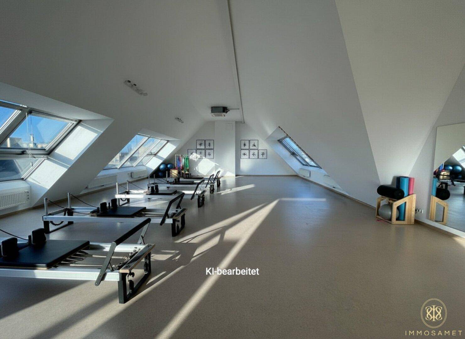 Geräumiger Fitnessraum im Dachgeschoss mit Pilates-Geräten und viel Tageslicht.