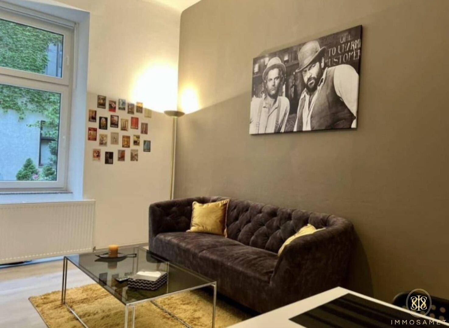 Helles Wohnzimmer mit Fenster und Blick ins Grüne, ausgestattet mit einem bequemen Sofa.