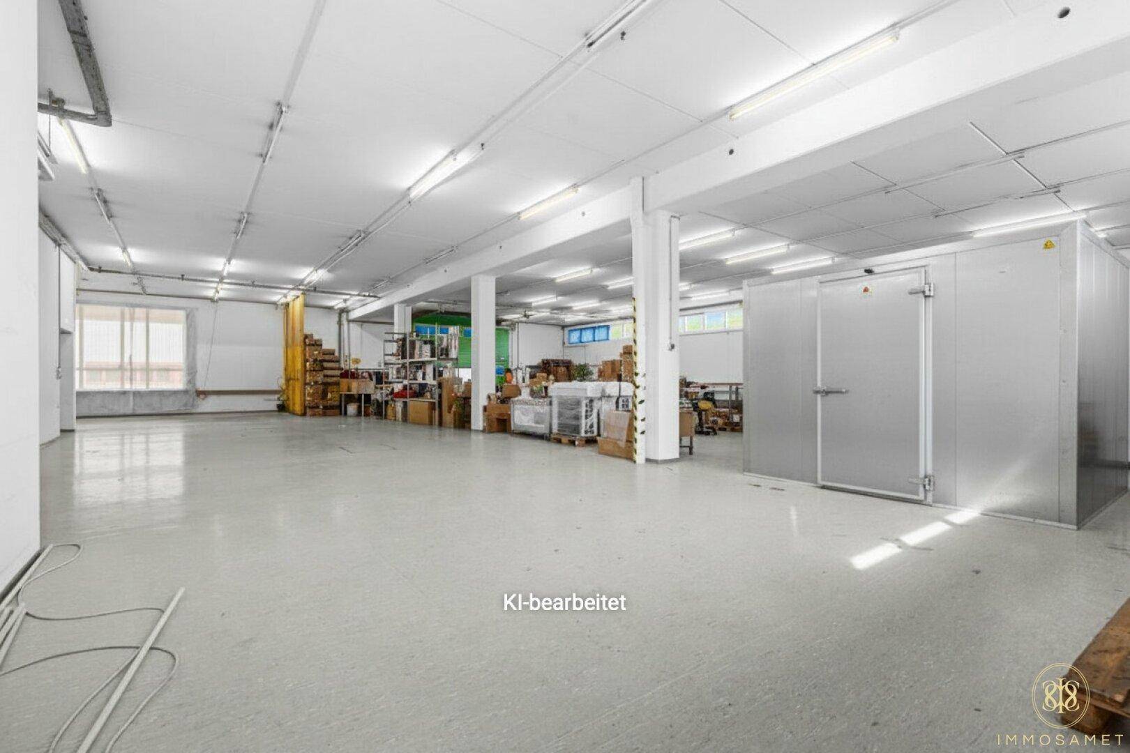 Leerer Lagerraum mit hohen Decken, Betonboden und großen industriellen Kühlkammern an der Wand, bereit zur Nutzung.