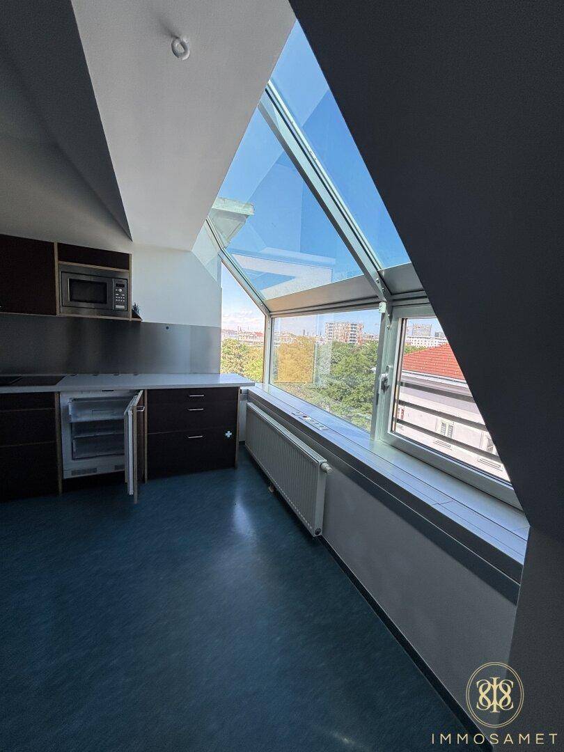Detailansicht der Küche mit Einbaugeräten und dem großen Dachfenster, das eine weite Aussicht bietet.