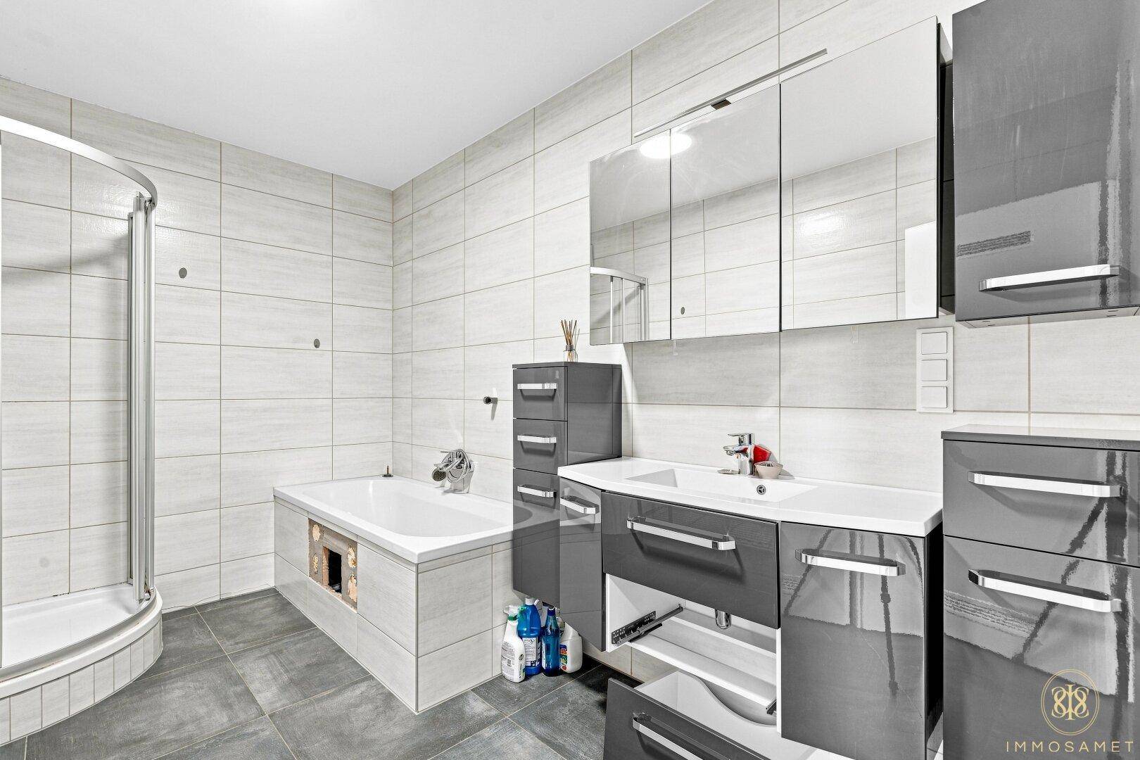 Modernes Badezimmer mit Badewanne, Dusche und Doppelwaschbecken, ideal für Familien.