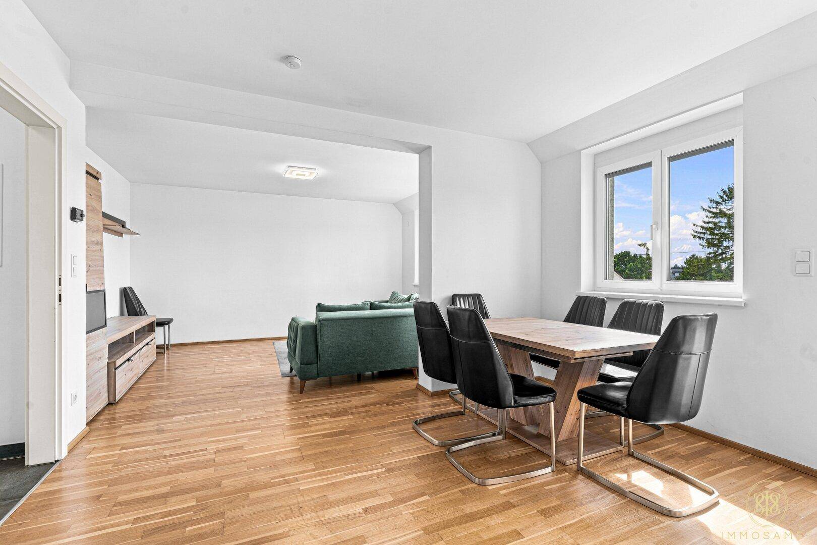 Geräumiger Wohn-Essbereich mit Holzboden, Esstisch und offener Verbindung zum Wohnbereich.