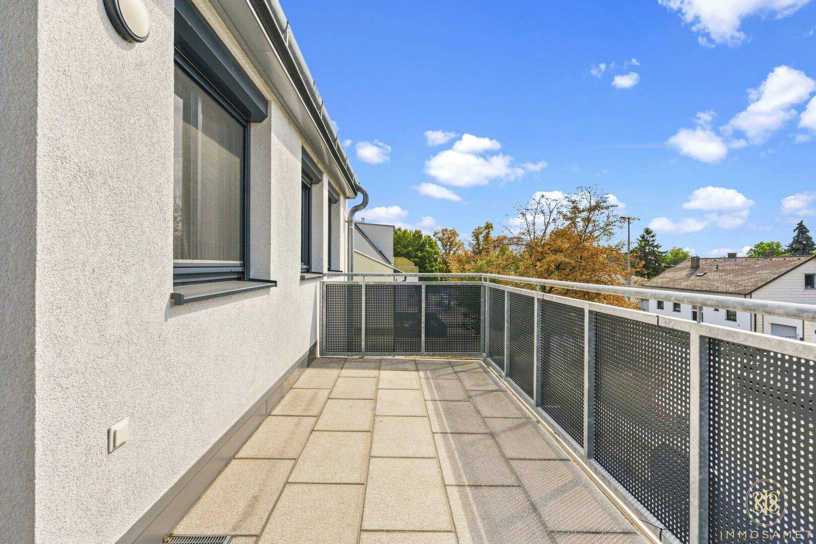 Geräumiger Balkon mit Fliesenboden und modernem Metallgeländer, ideal für Entspannung im Freien.