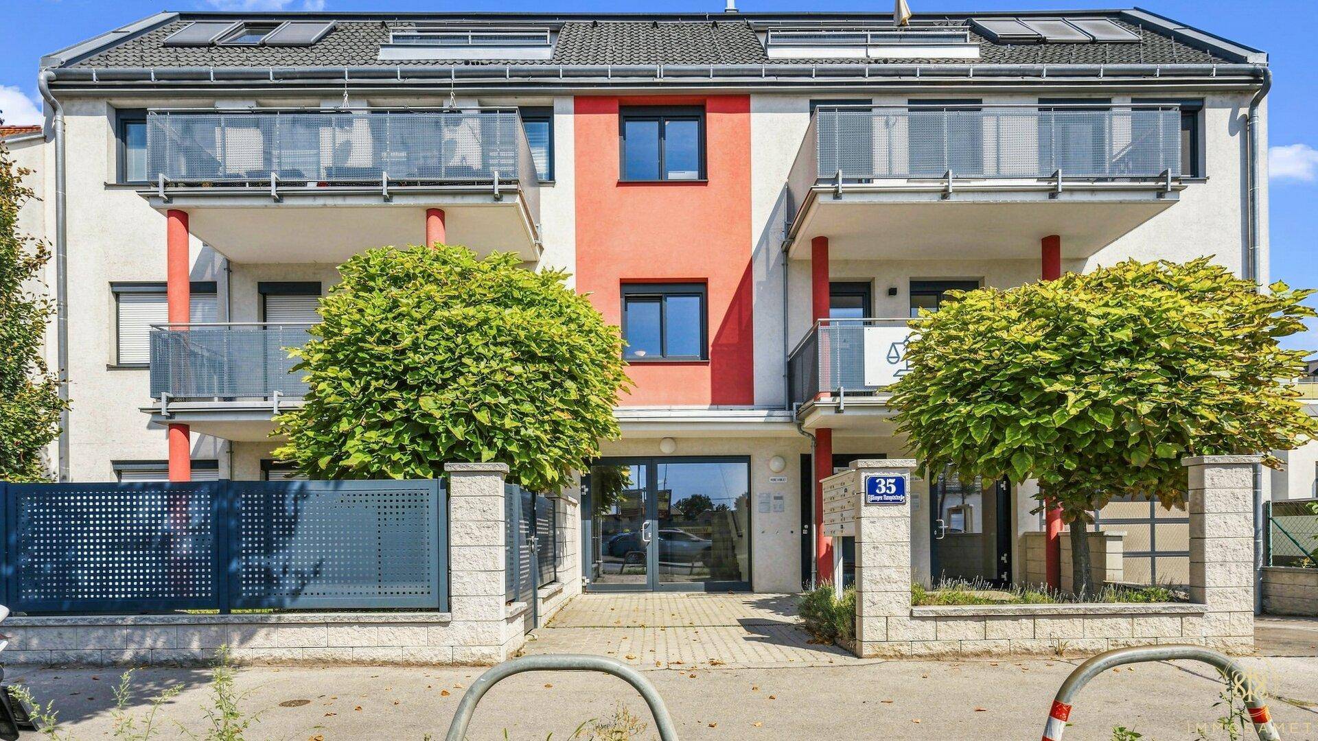 Modernes Mehrfamilienhaus mit Balkonen, großen Fenstern und einer gepflegten Fassade.