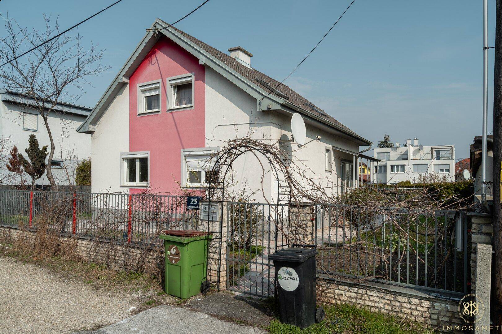 Seitenansicht des Hauses mit Vorgarten, Eingangstor und Blick auf die ruhige Wohngegend.