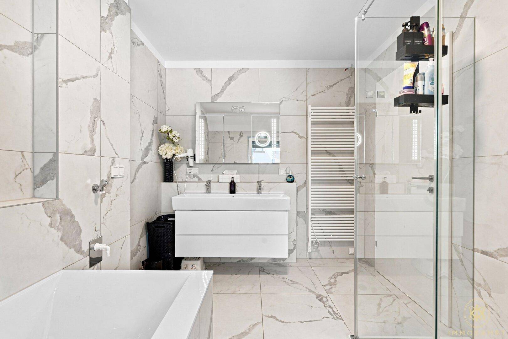 Elegantes Badezimmer mit Doppelwaschbecken, Badewanne und großer Dusche.