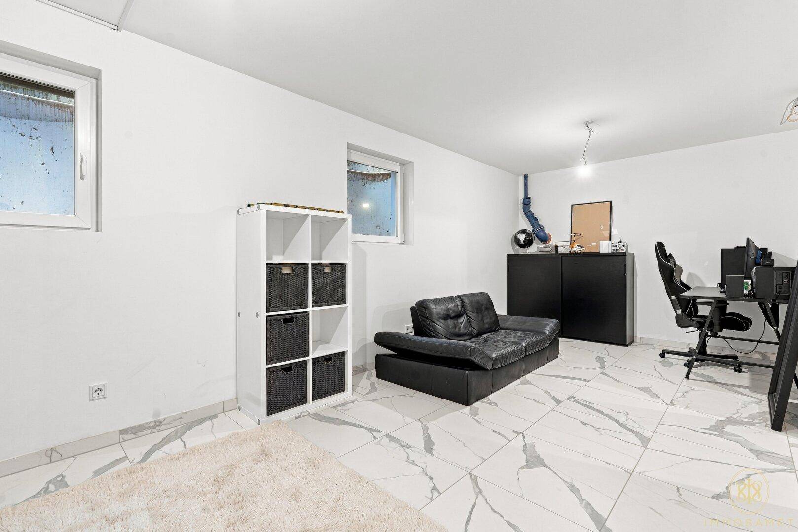 Geräumiger Kellerraum mit Tageslichtfenstern, ideal als Hobby- oder Arbeitszimmer.