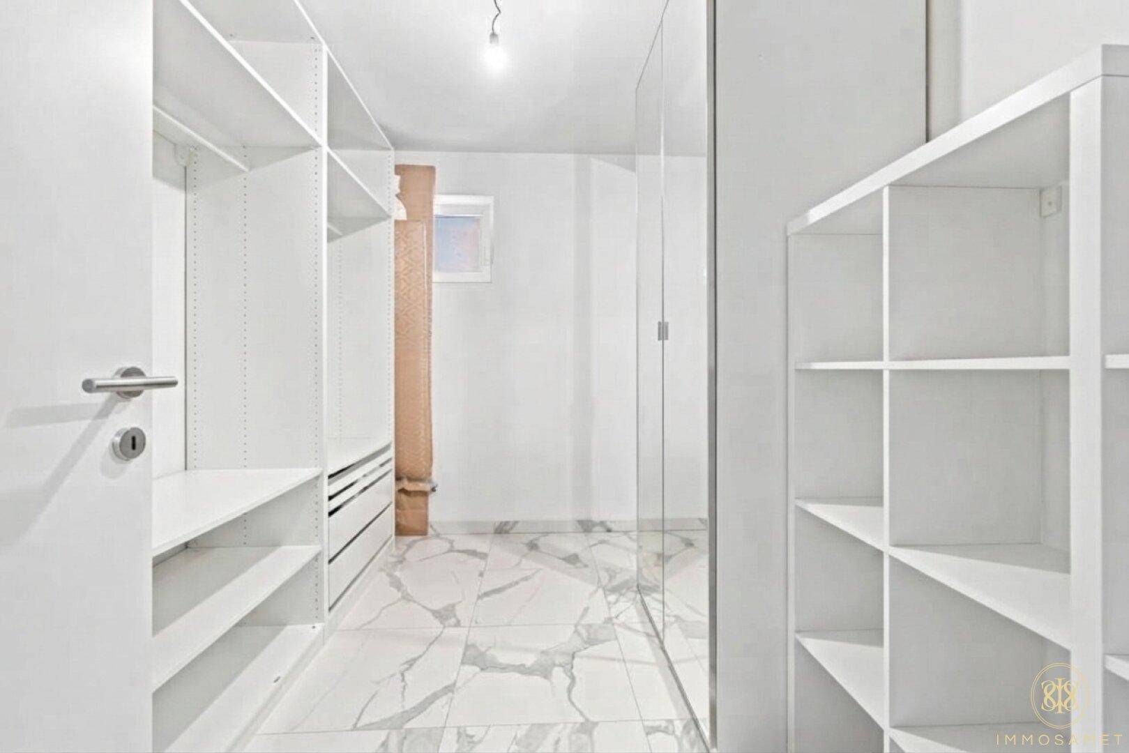Begehbarer Kleiderschrank im Untergeschoss mit viel Stauraum und Regalsystemen.