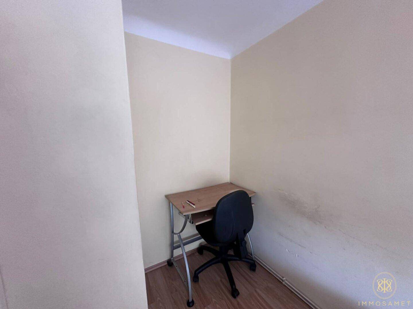 Kleiner Arbeitsbereich mit Schreibtisch und Bürostuhl, ideal für Home-Office oder Lernzwecke.