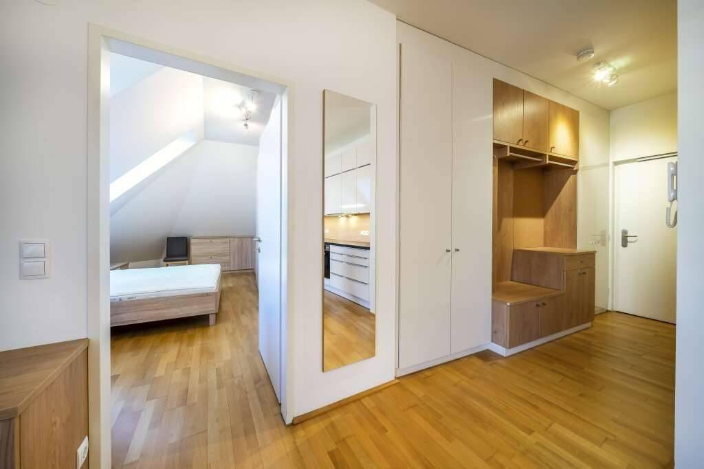 Eingangsbereich mit praktischen Einbauschränken und einem großen Spiegel, der zum Schlafzimmer führt.