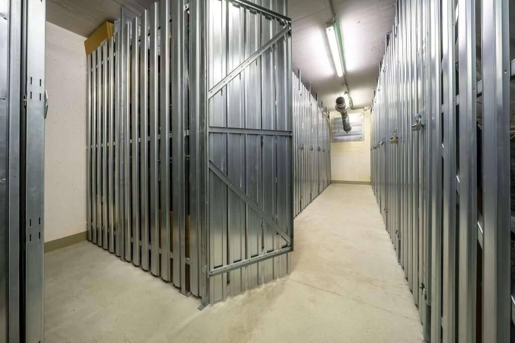 Kellerabteil mit zahlreichen Metall-Lagereinheiten für zusätzlichen Stauraum.