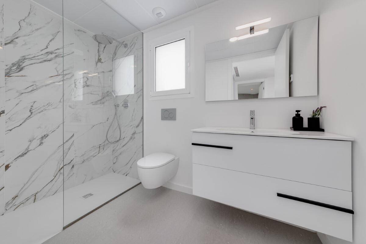 Modernes Badezimmer mit begehbarer Dusche, Marmorfliesen und schwebendem Waschtisch.