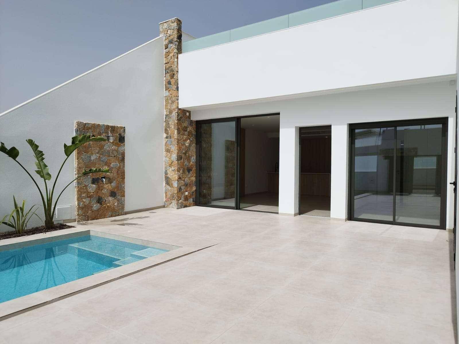 Elegante Hausfassade mit Steinakzenten und einem kleinen Poolbereich für Entspannung.