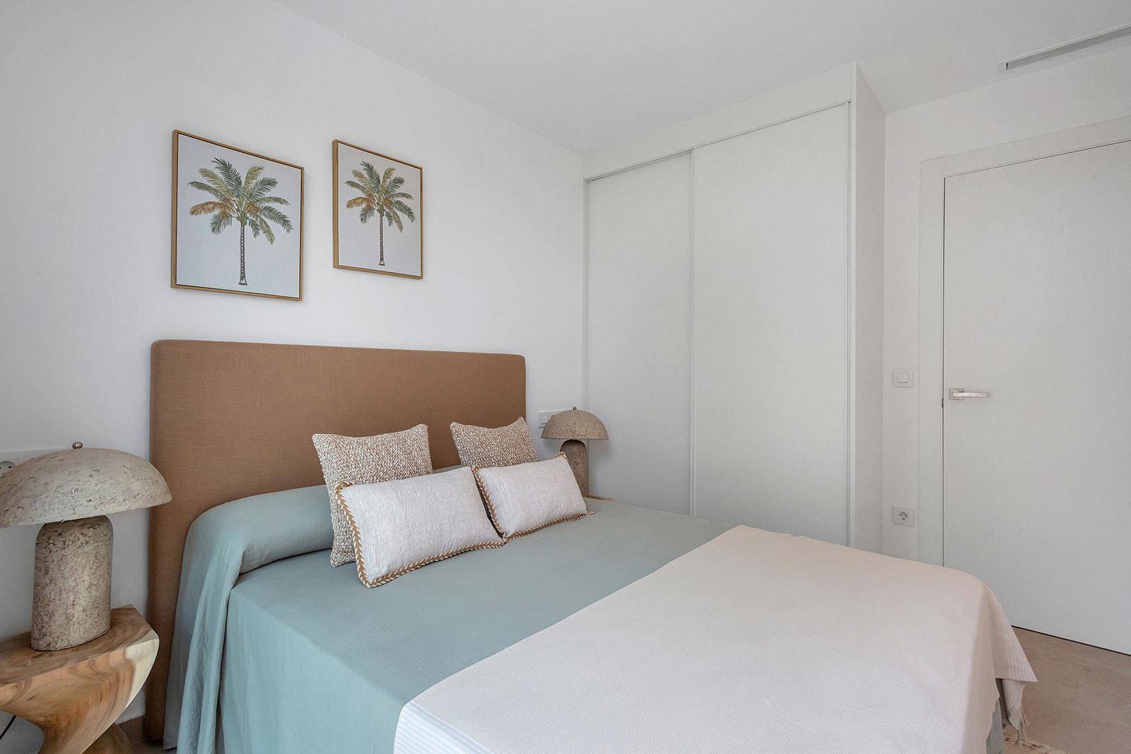 Schlafzimmer mit integrierten weißen Schränken und schlichtem, modernem Design.