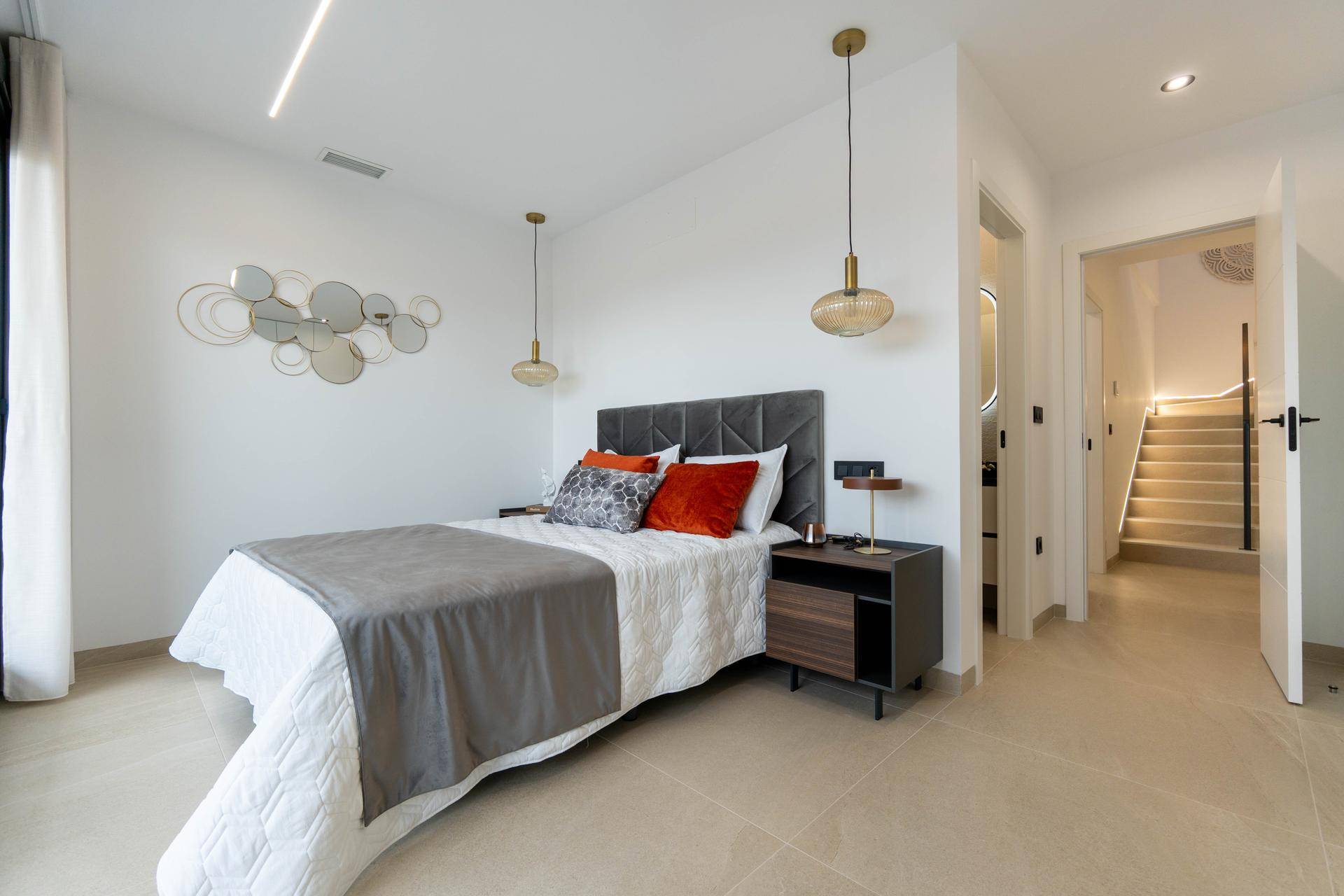 Modernes Schlafzimmer mit stilvollem Kopfteil, Nachttischen und indirekter Beleuchtung.