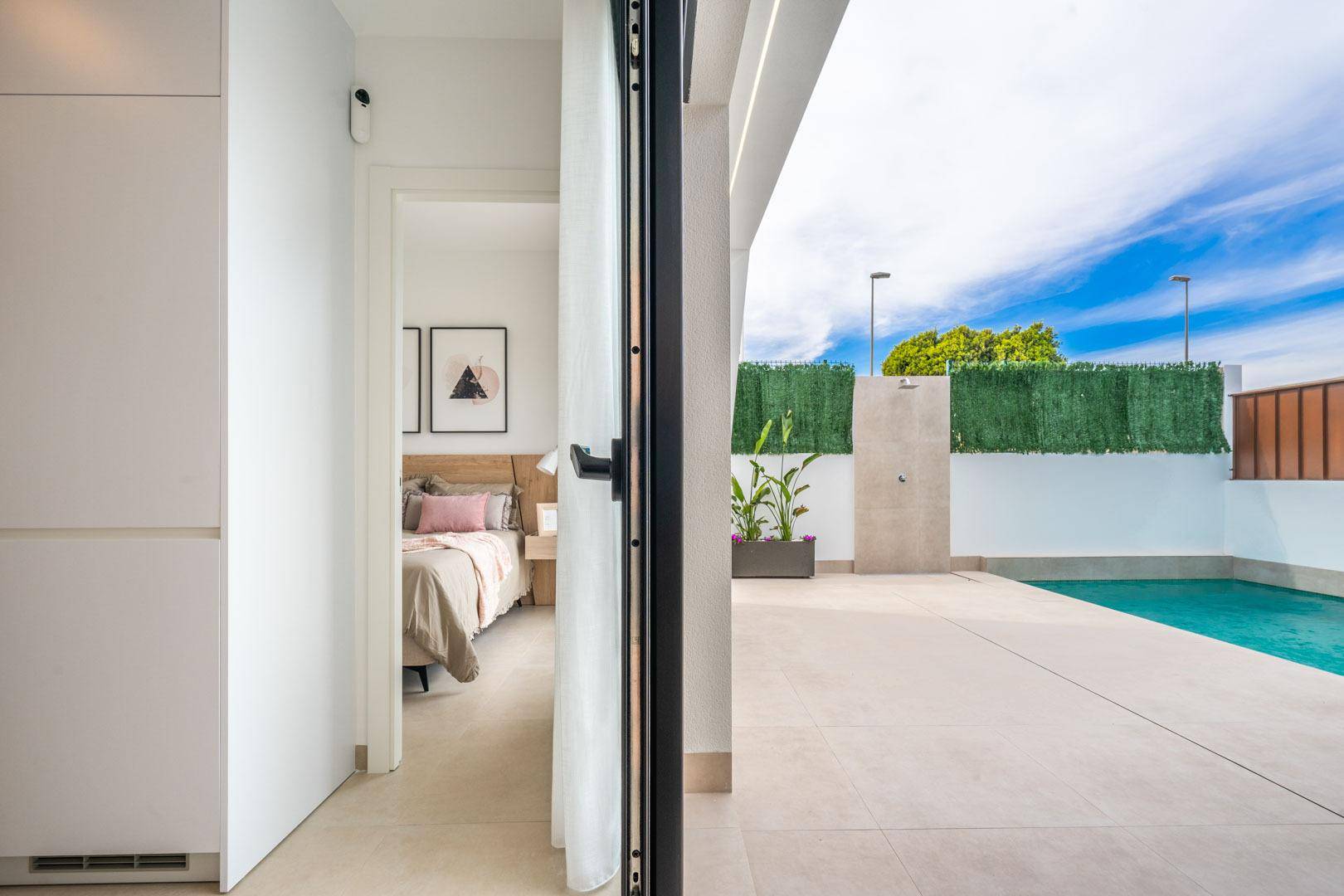 Blick vom Schlafzimmer auf den sonnigen Poolbereich mit Außendusche.