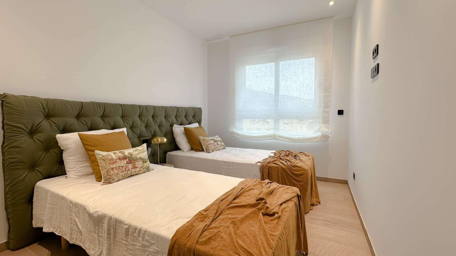 Helles Schlafzimmer mit zwei Einzelbetten, großem Fenster und modernem Design.
