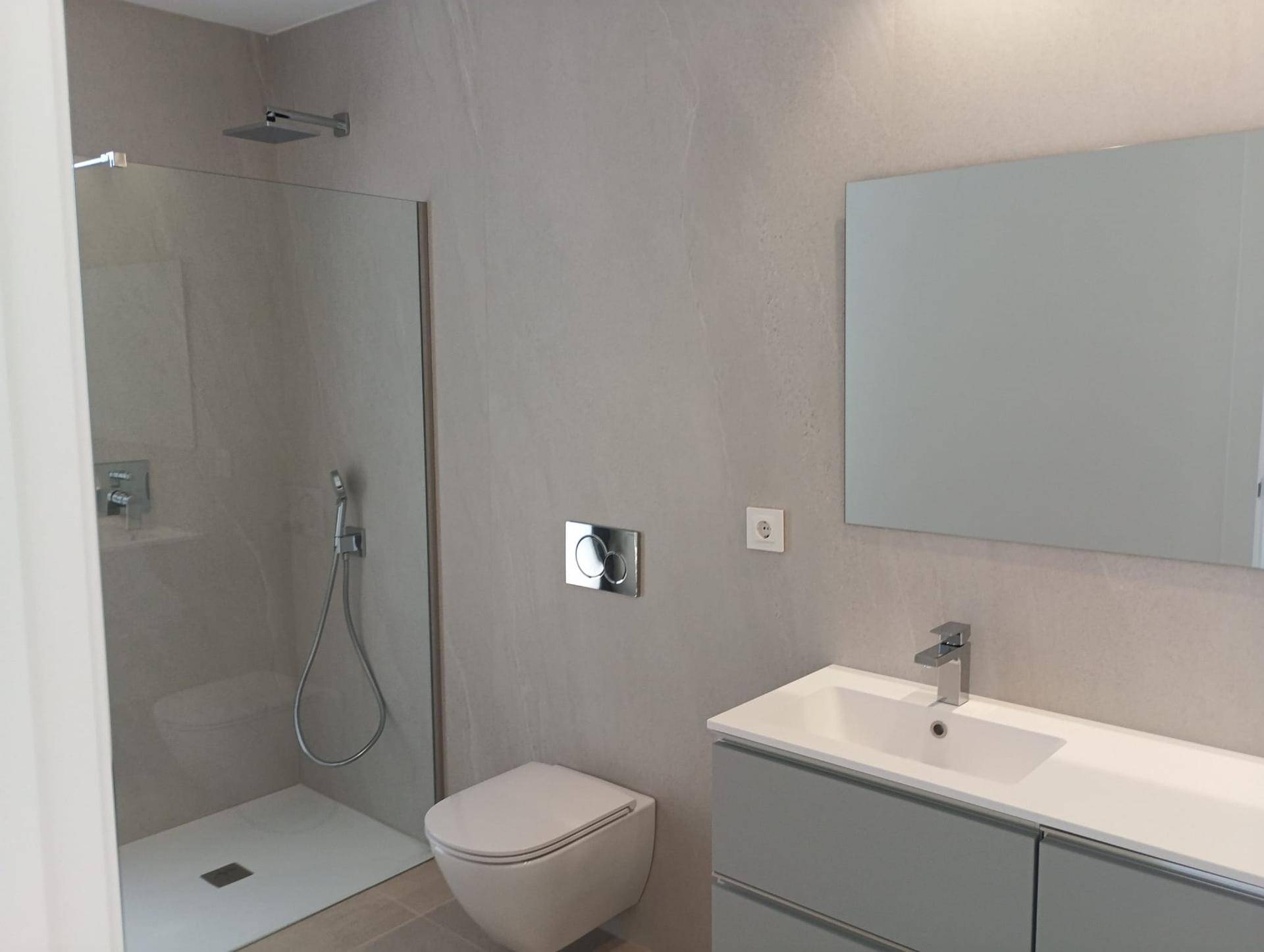 Modernes Badezimmer mit ebenerdiger Dusche, schwebendem Waschtisch und Wand-WC.