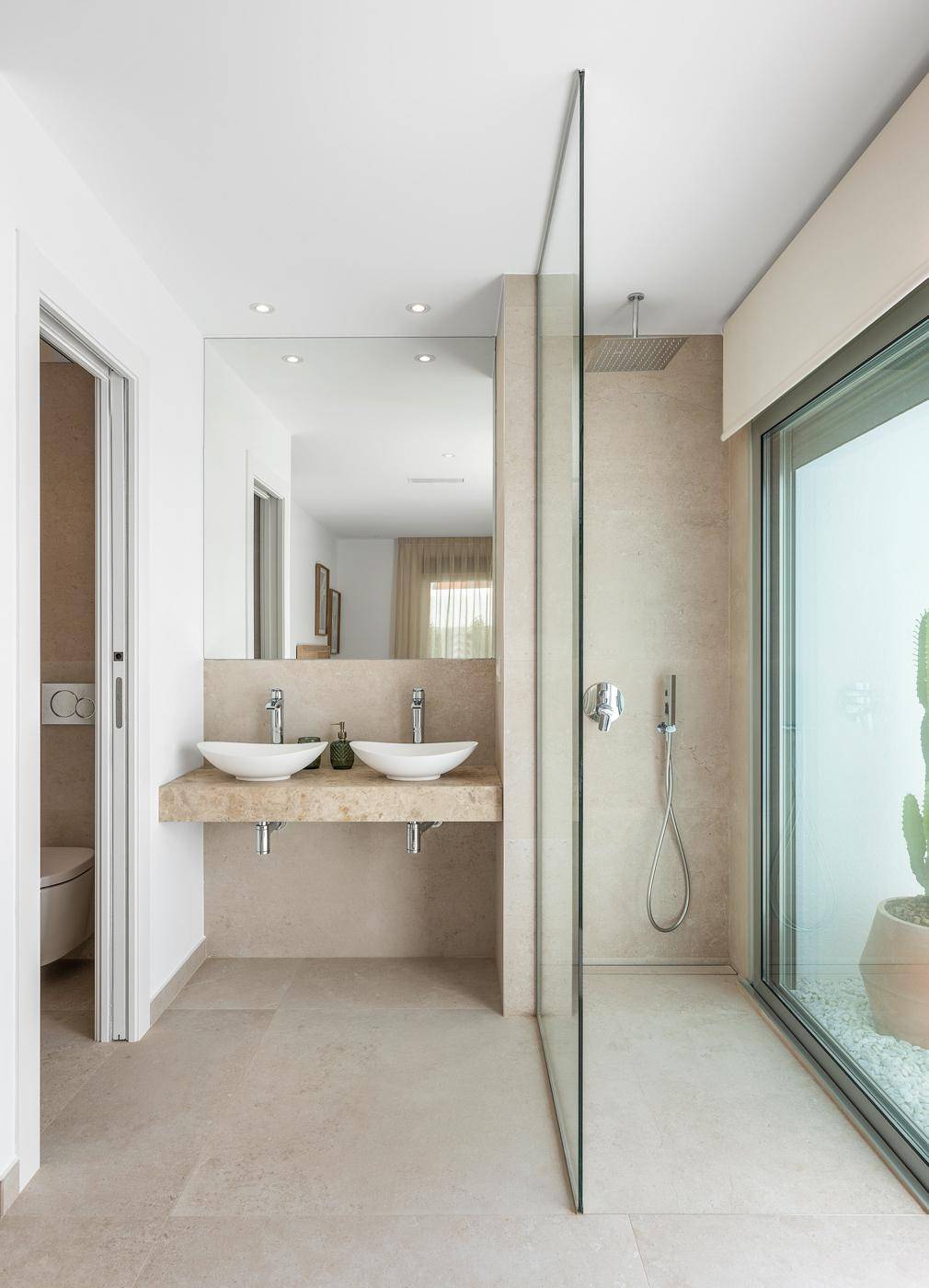 Modernes Badezimmer mit Doppelwaschbecken, begehbarer Dusche und Poolblick.