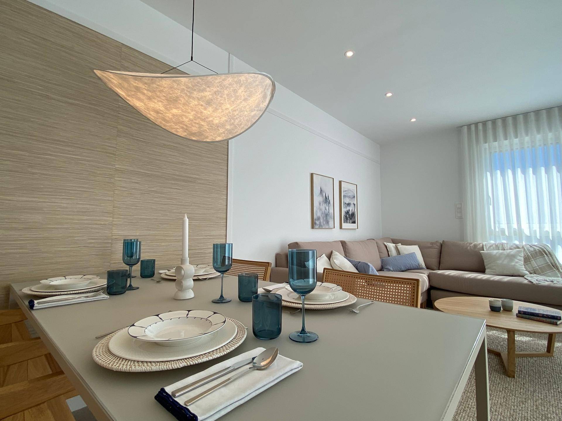 Eleganter Essbereich mit gedecktem Tisch und Blick auf das helle Wohnzimmer.