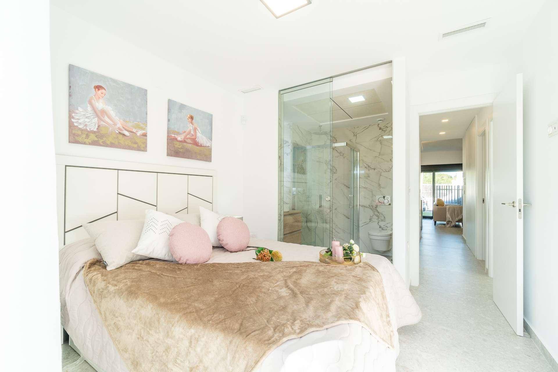 Modernes Schlafzimmer mit direktem Zugang zu einem eleganten Bad mit Glasduschkabine.