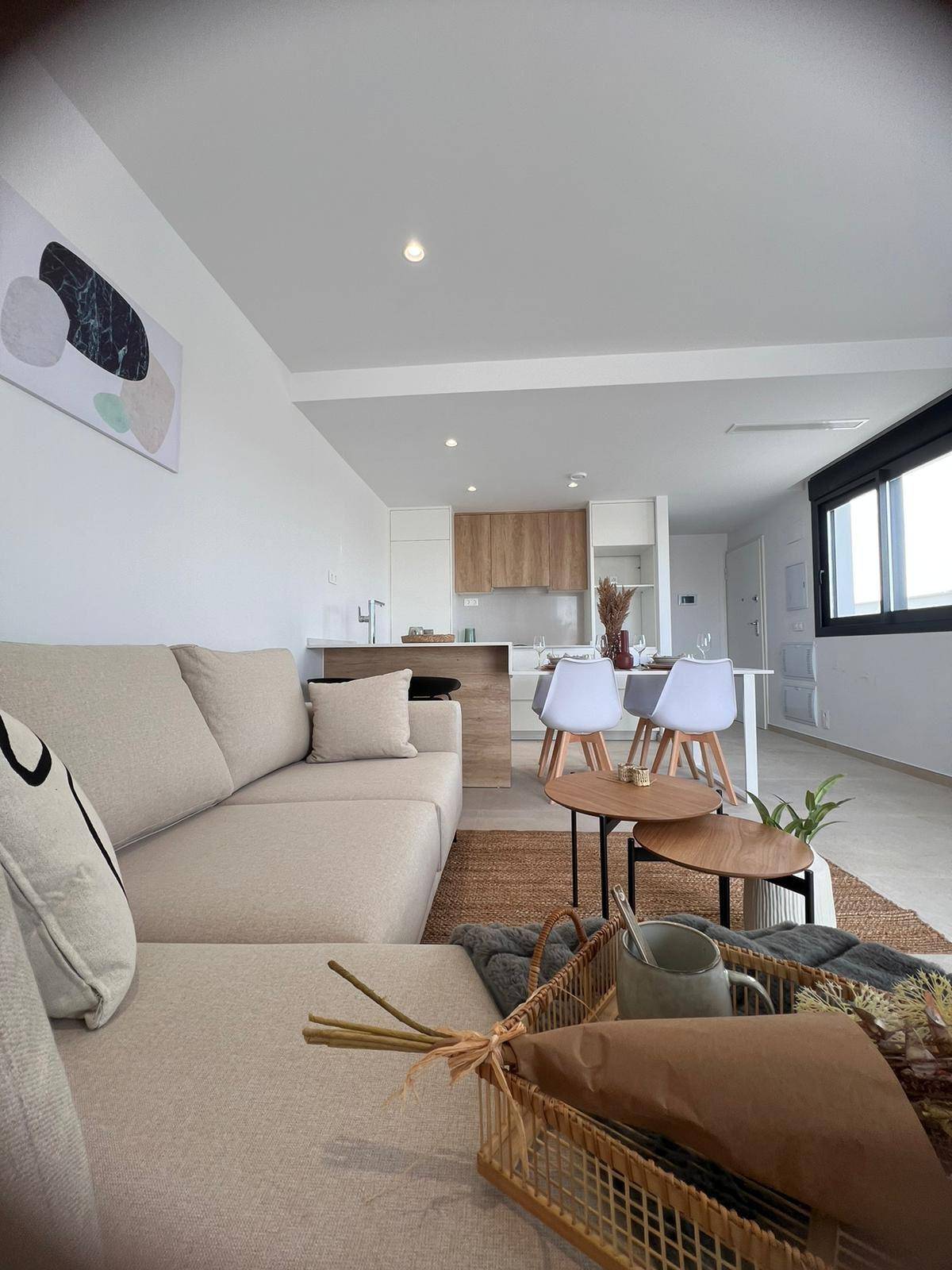 Gemütlicher Wohnbereich mit Sofa, Couchtischen und Blick auf die offene Küche.