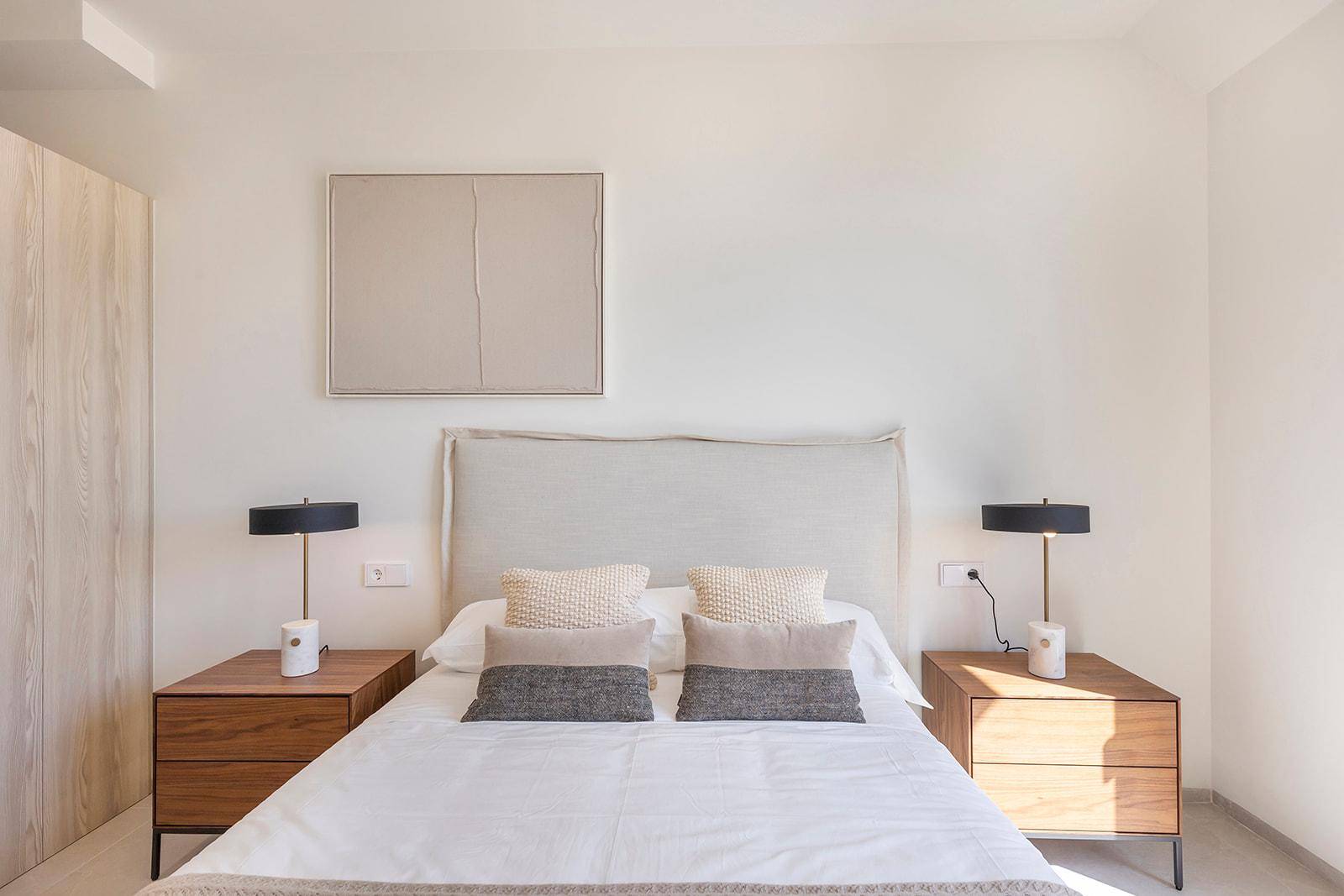 Helles Schlafzimmer mit Doppelbett, Nachttischen und minimalistischer Dekoration.