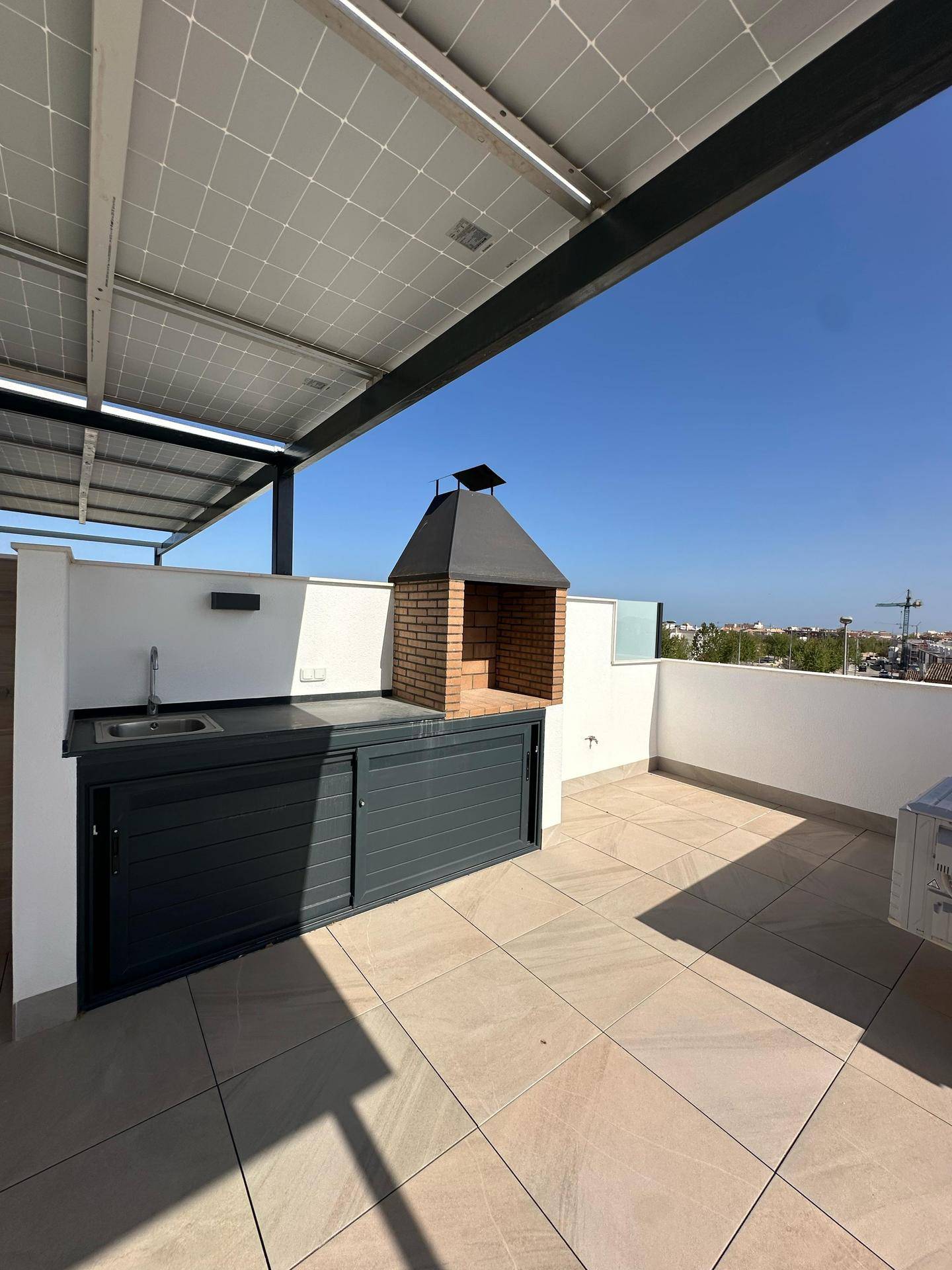 Geräumige Dachterrasse mit integrierter Außenküche und gemauertem Grill für gesellige Abende.