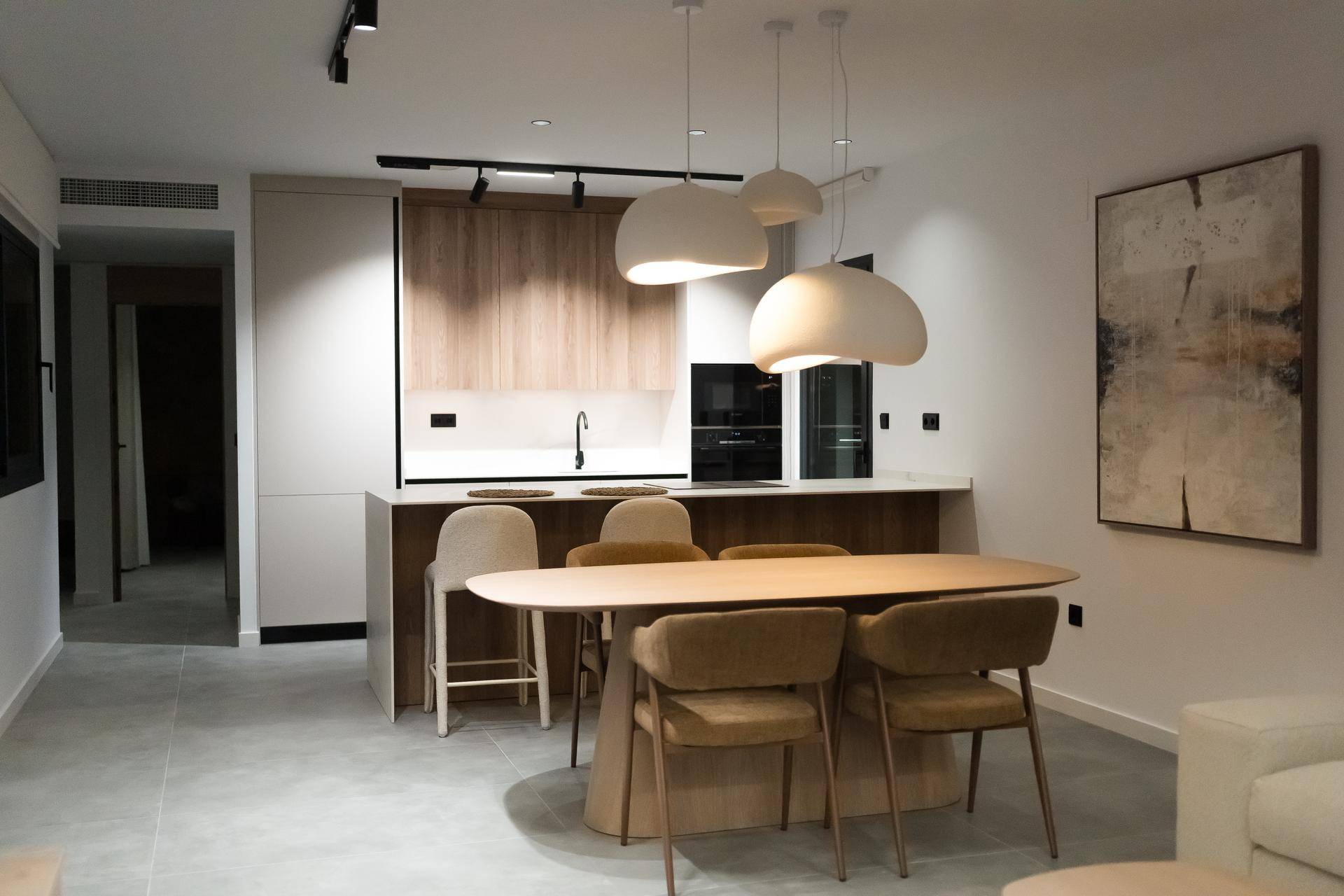 Moderne Küche mit Essbereich, Kücheninsel und stilvollen Pendelleuchten.