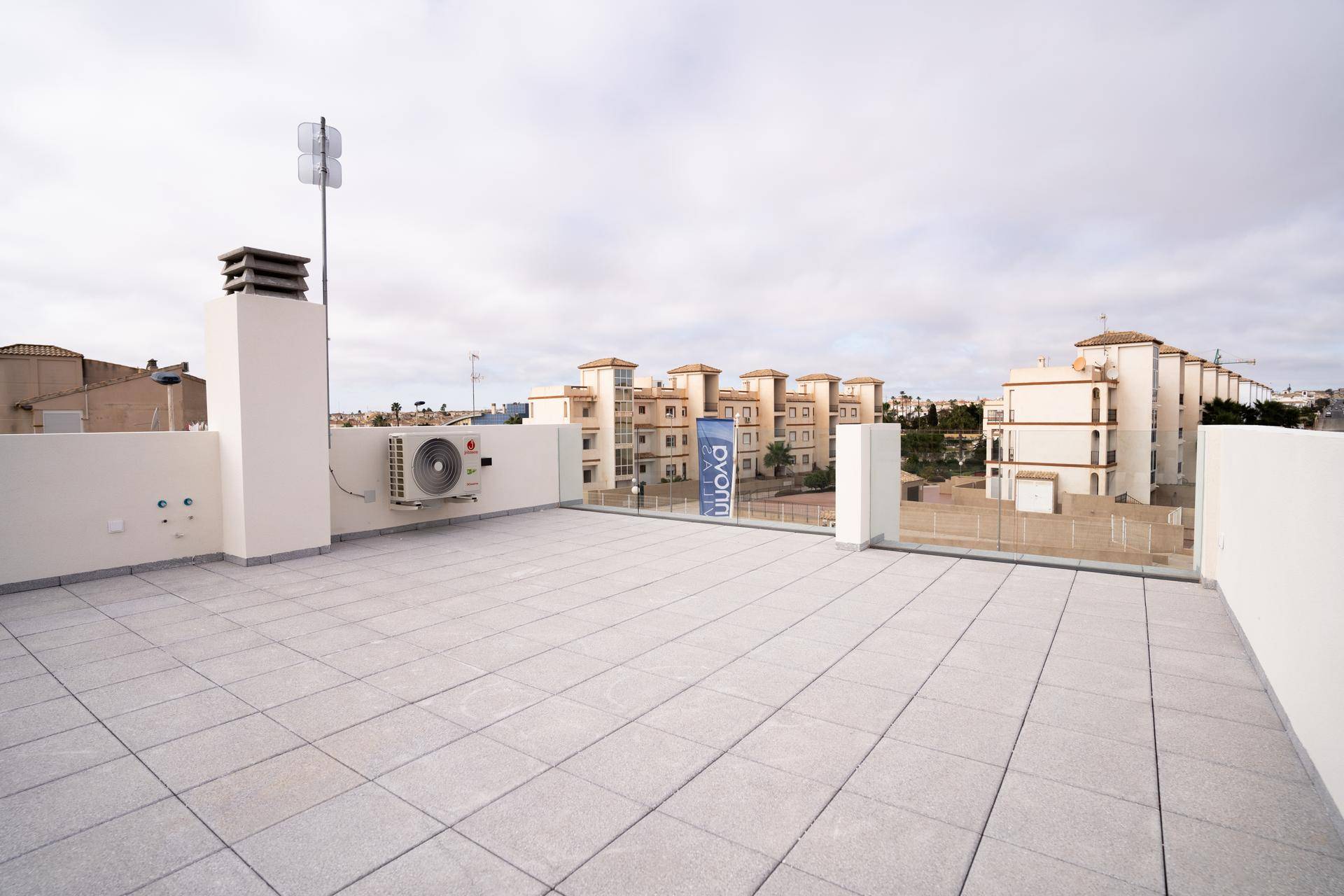 Weitläufige Dachterrasse mit Klimaanlage und Blick auf die umliegenden Gebäude.