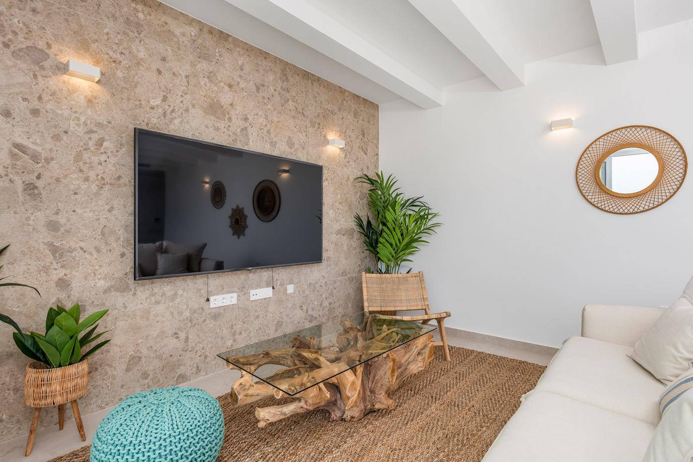 Gemütliches Wohnzimmer mit Steinfassade, modernem TV und Terrassenzugang.