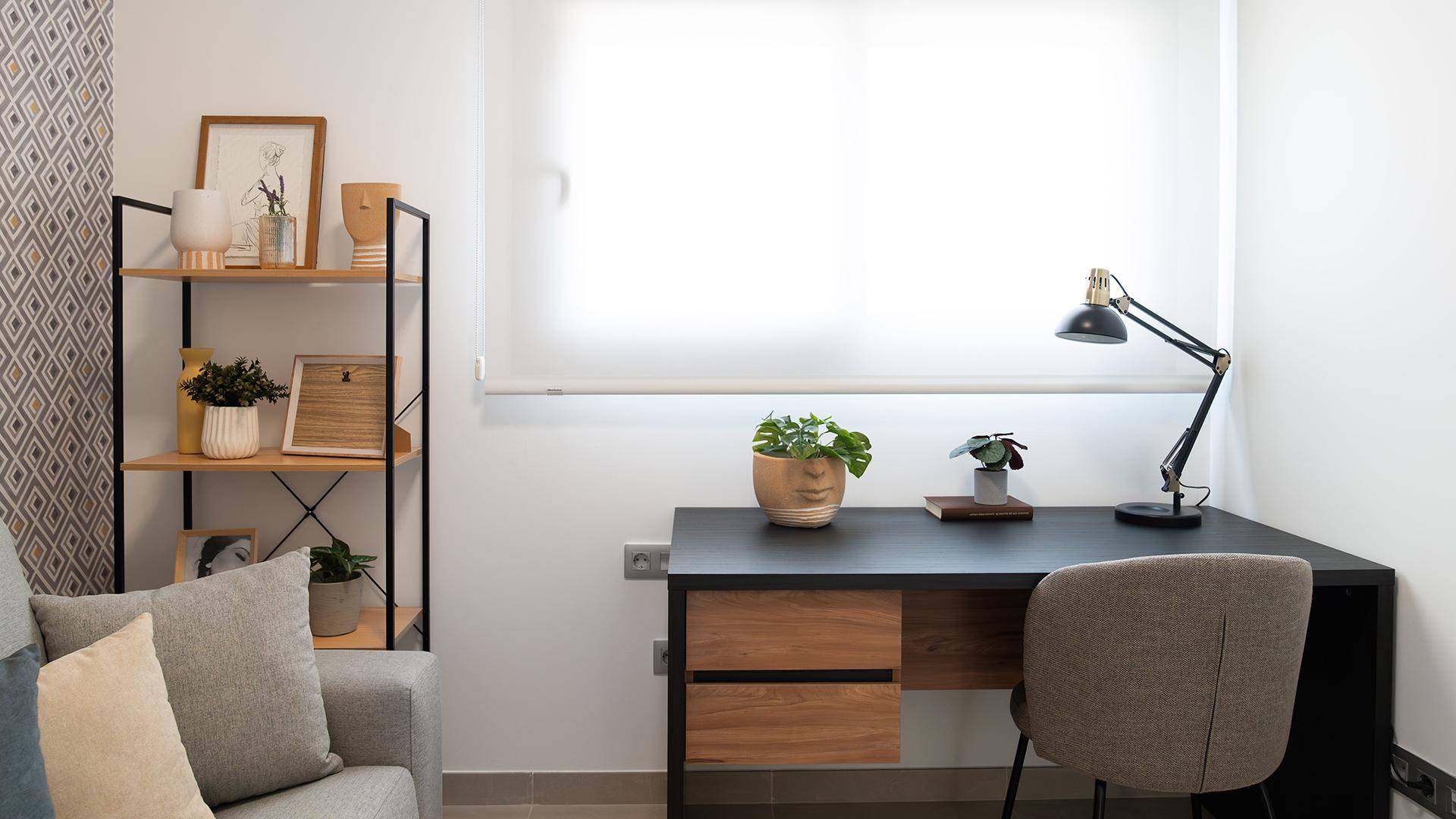 Helles Arbeitszimmer mit Schreibtisch, Regal und minimalistischer Einrichtung.