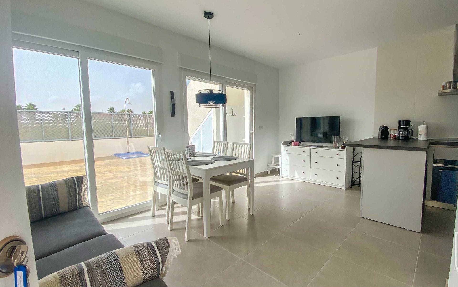 Lichtdurchfluteter Wohn- und Essbereich mit Zugang zur Terrasse und Poolblick.
