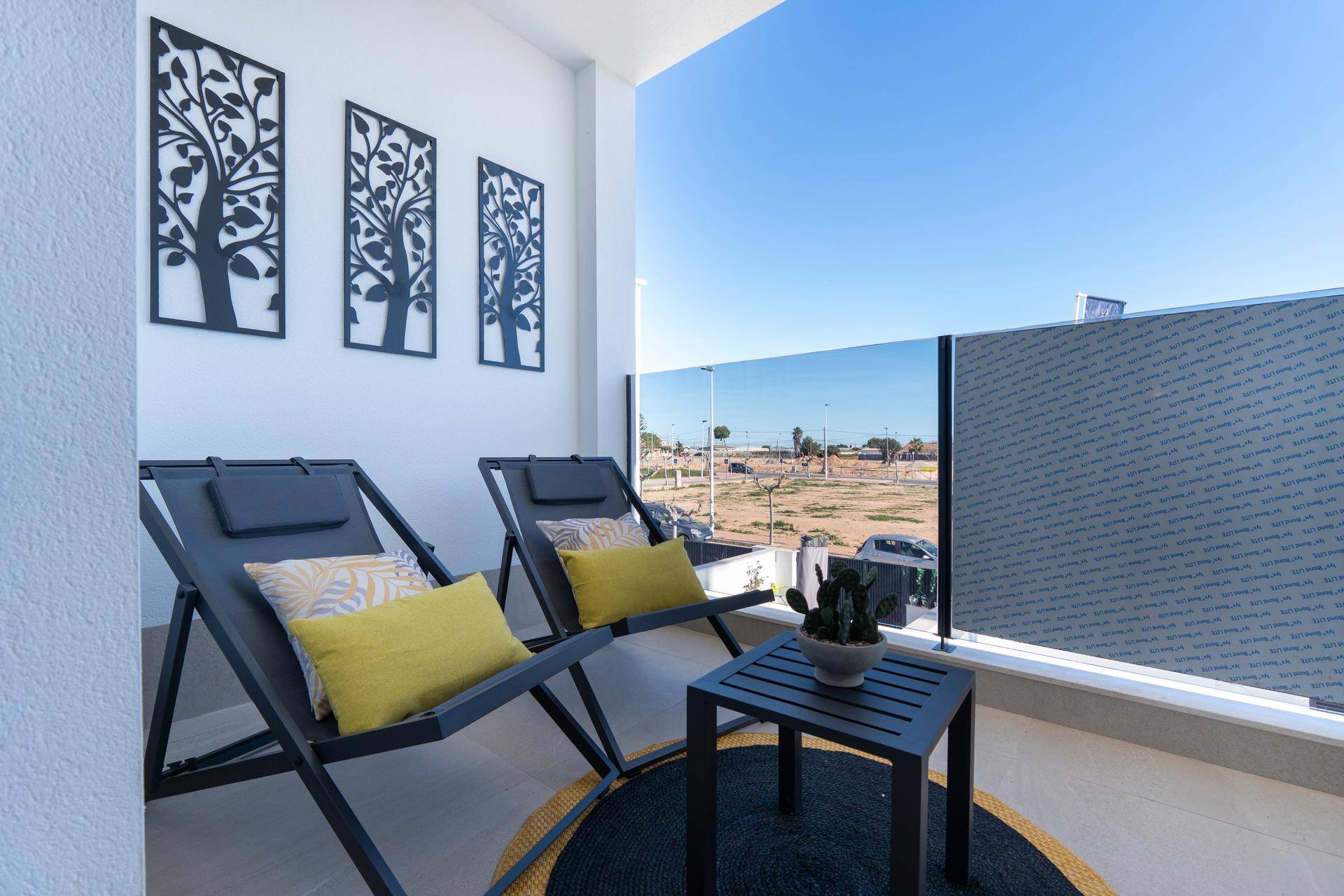 Heller Balkon mit modernen Liegestühlen und dekorativen Elementen, ideal zum Entspannen.