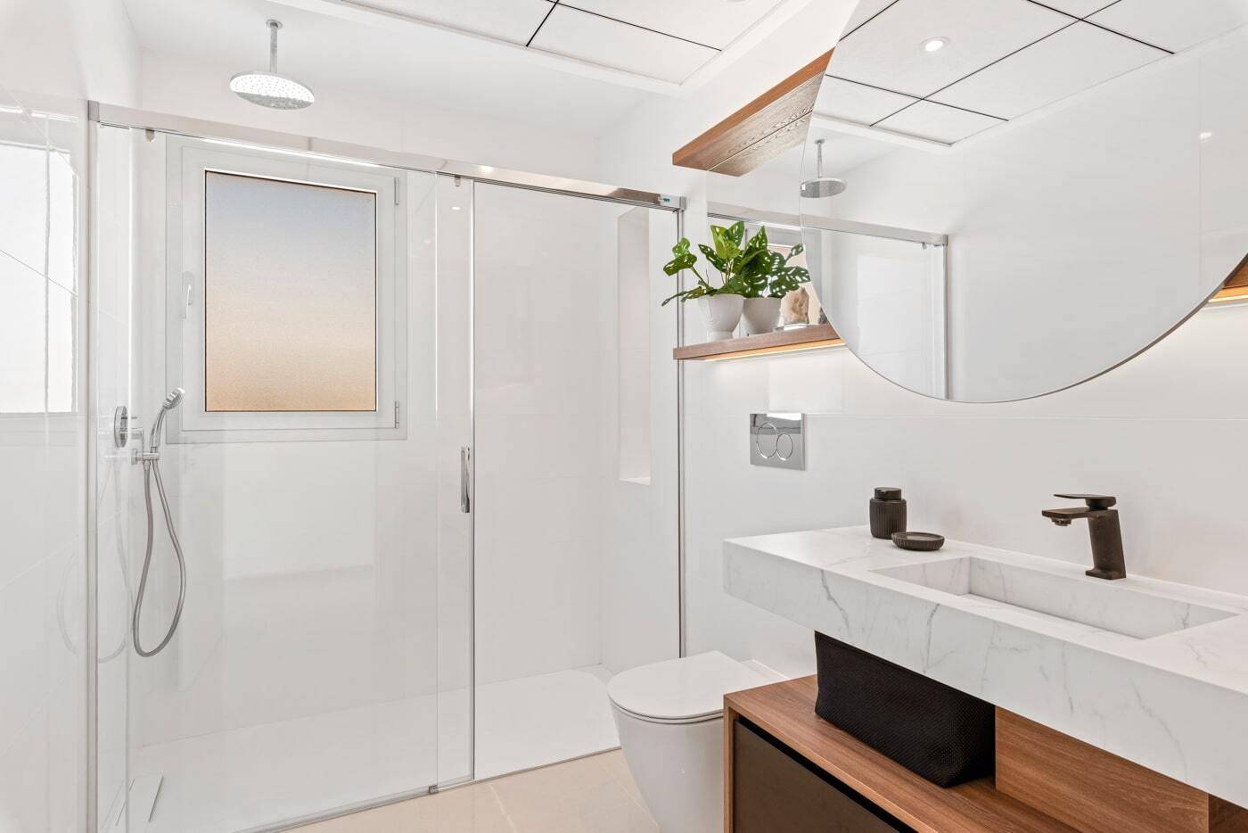 Modernes Badezimmer mit begehbarer Dusche, schwebendem Waschtisch und Fenster.