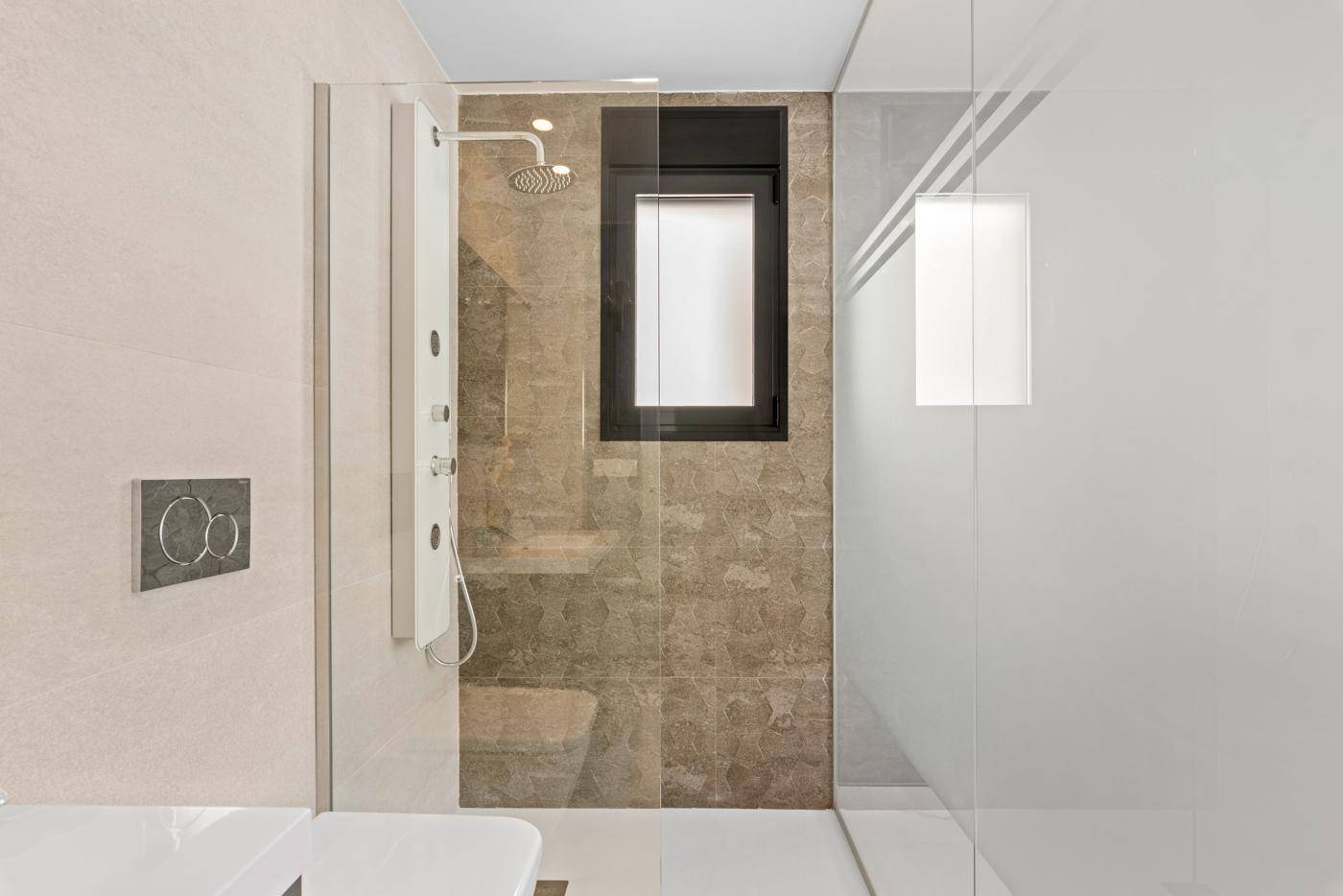 Duschbereich im modernen Badezimmer mit Regendusche und Fenster.