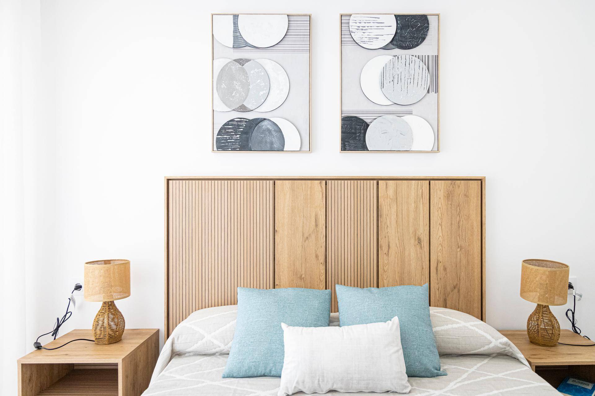 Gemütliches Schlafzimmer mit Doppelbett, Holz-Kopfteil und Nachttischen mit Lampen.