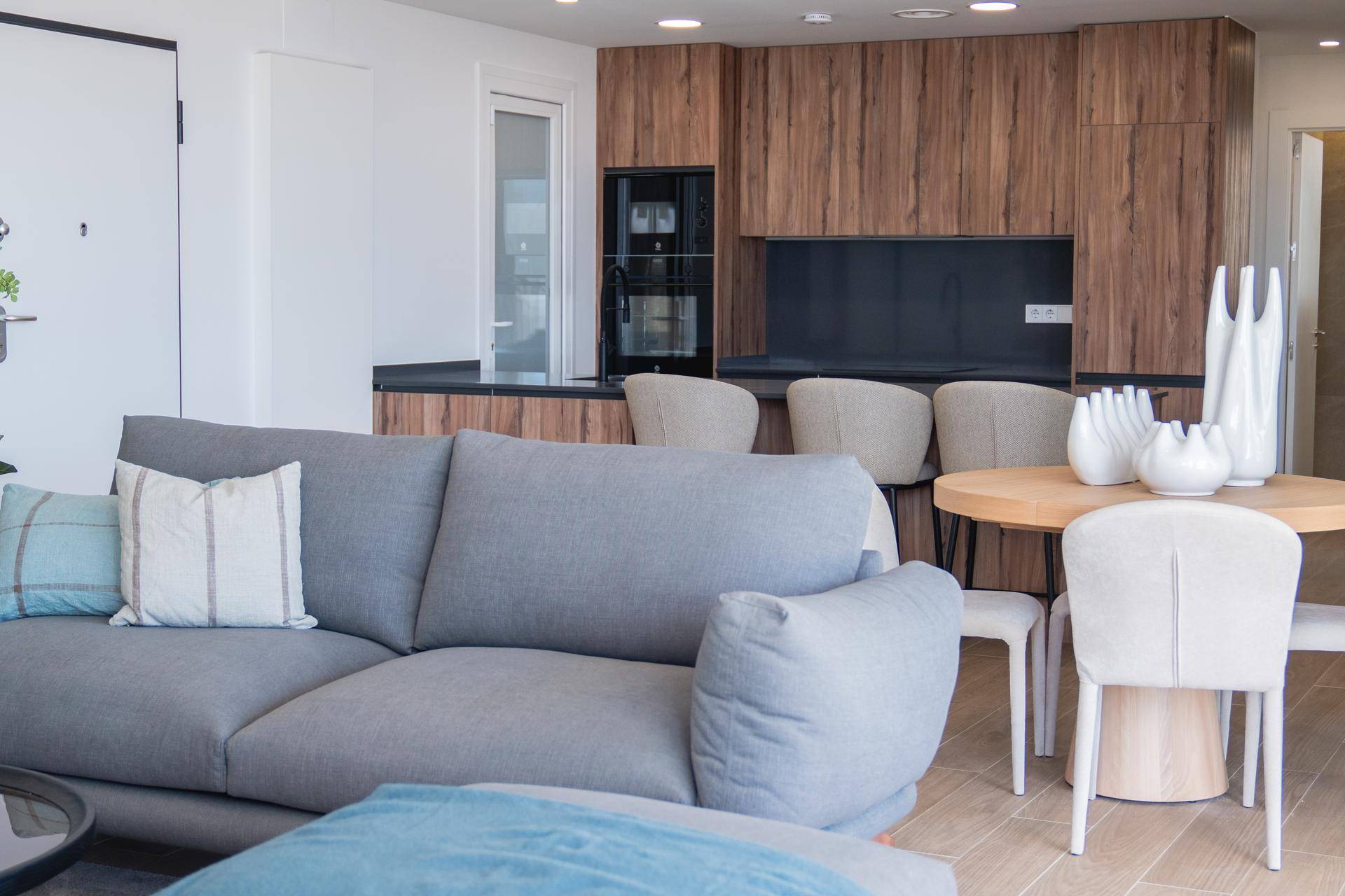 Offener Wohnbereich mit bequemen Sofas und Blick auf die moderne Holzküche.