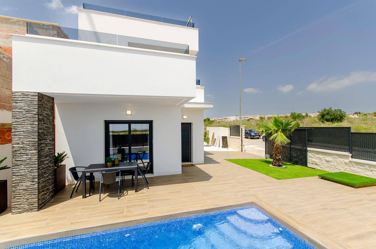 Moderne Villa mit Pool, möblierter Terrasse und Blick auf die Umgebung.