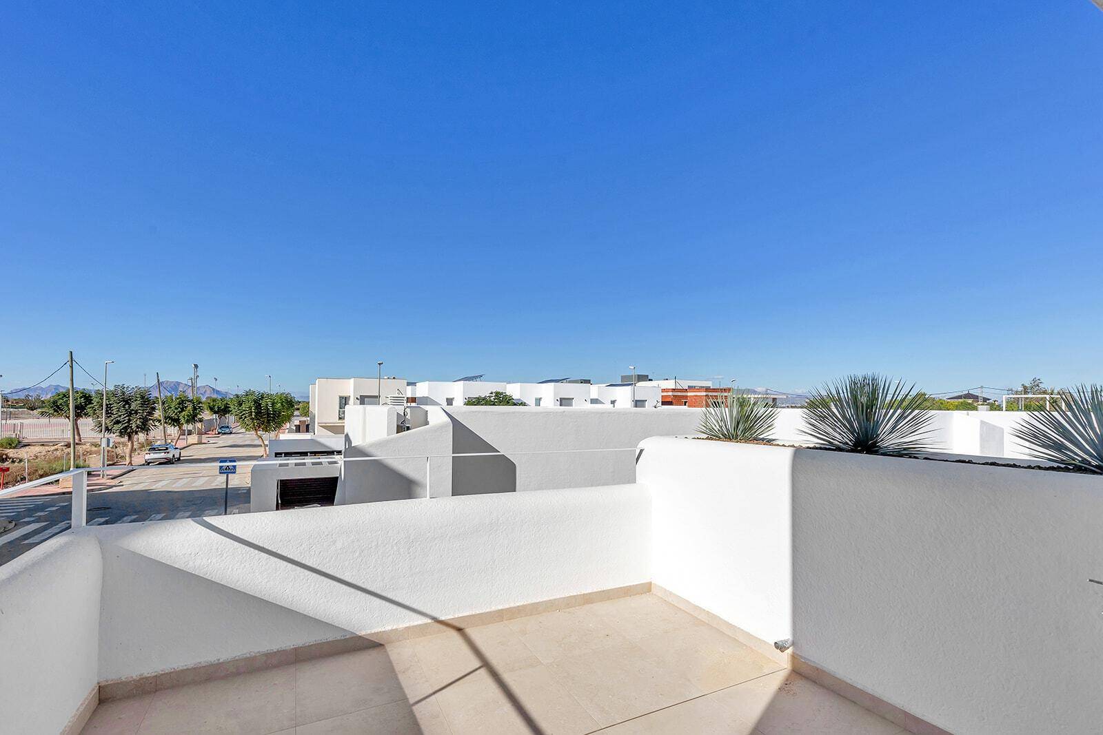 Sonniger Balkon mit weitem Blick über die Nachbarschaft und die umliegende Landschaft.