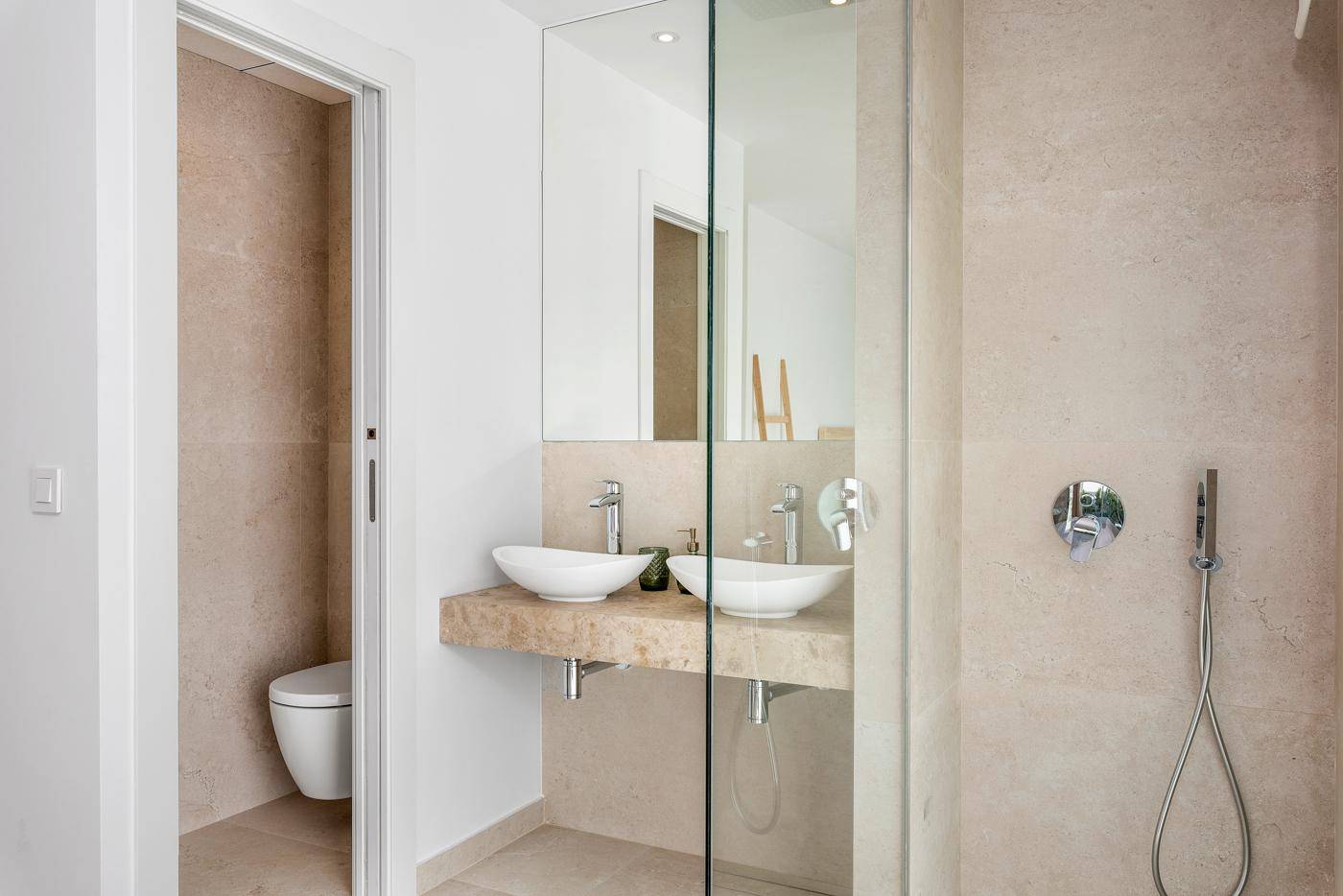 Modernes Badezimmer mit Doppelwaschbecken, begehbarer Dusche und separatem WC.